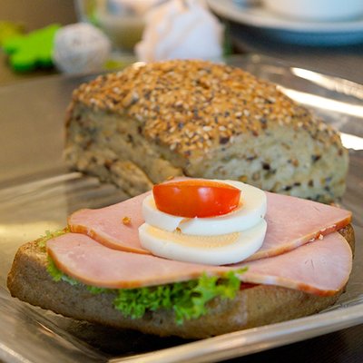 Ganzes krniges Brtchen mit Kassler belegt