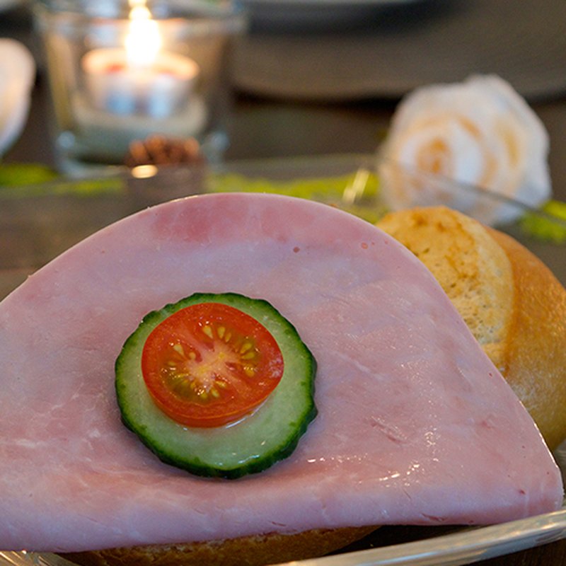 Halbes krosses Brötchen mit gekochtem Delikatess-Schinken belegt ...